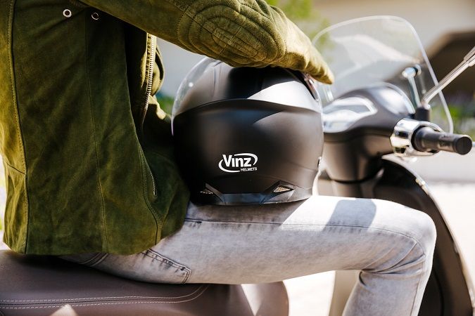 Past een systeemhelm in de buddy seat van de scooter?